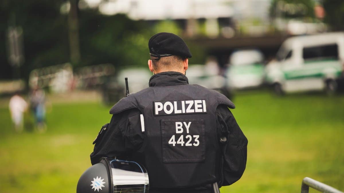 A police officer stands in uniform outdoors, highlighting law enforcement.