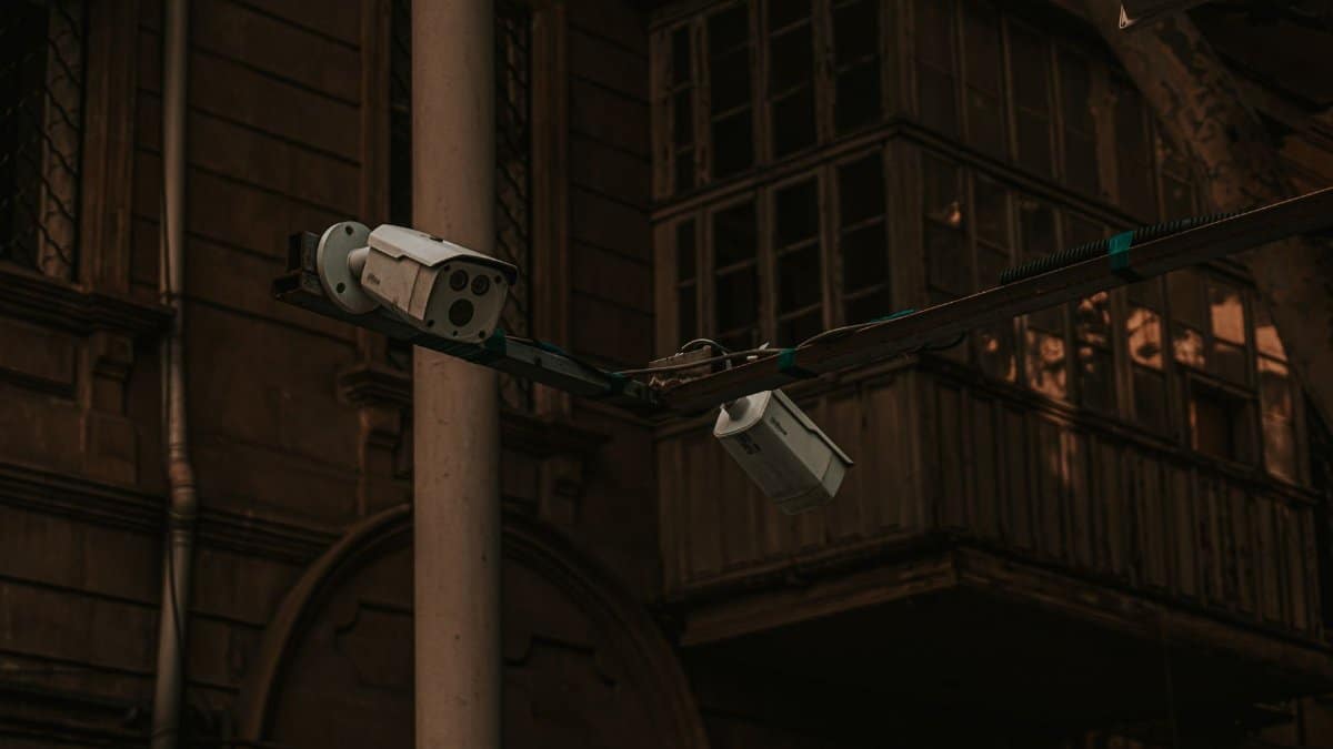 Street security cameras mounted on a pole in an urban environment, highlighting surveillance.