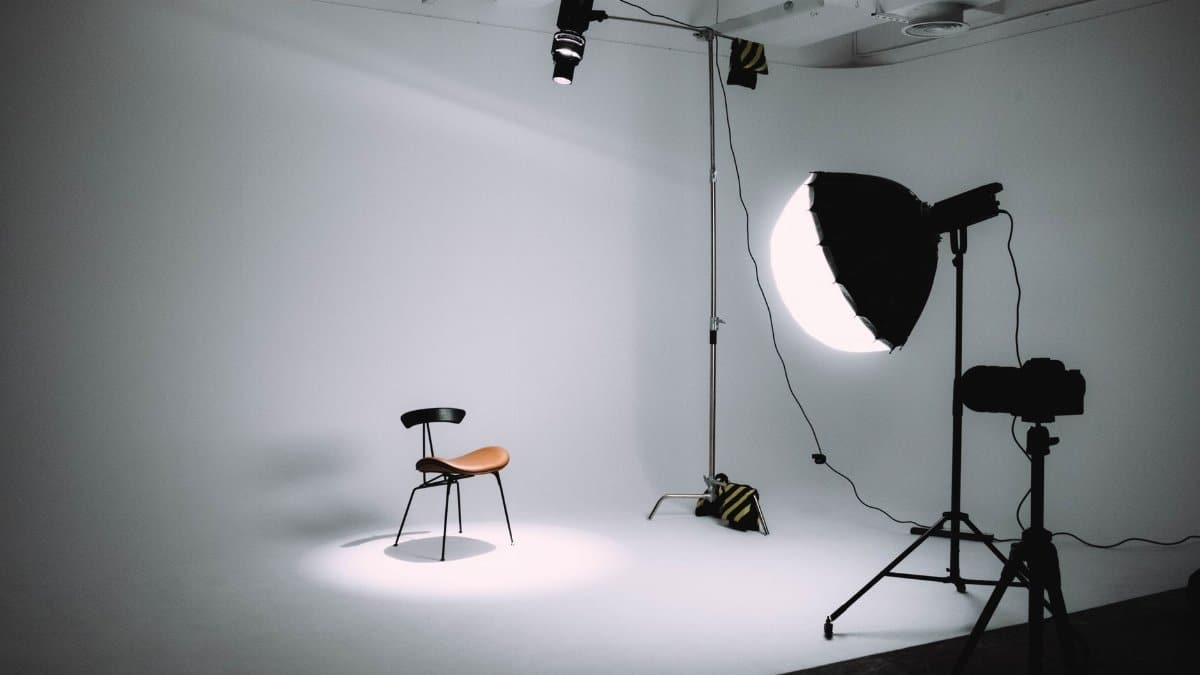 Empty photography studio with lighting equipment focused on a single chair.