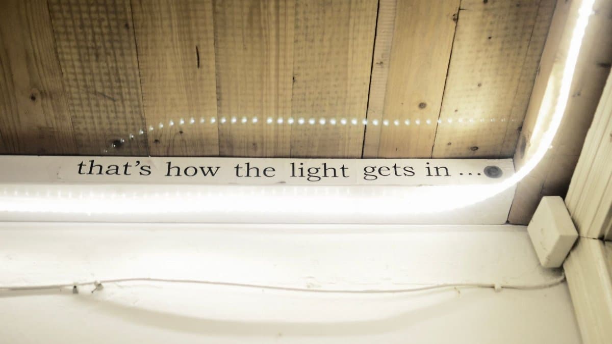 High angle of text written on window decorated with shiny lights reflecting in glass