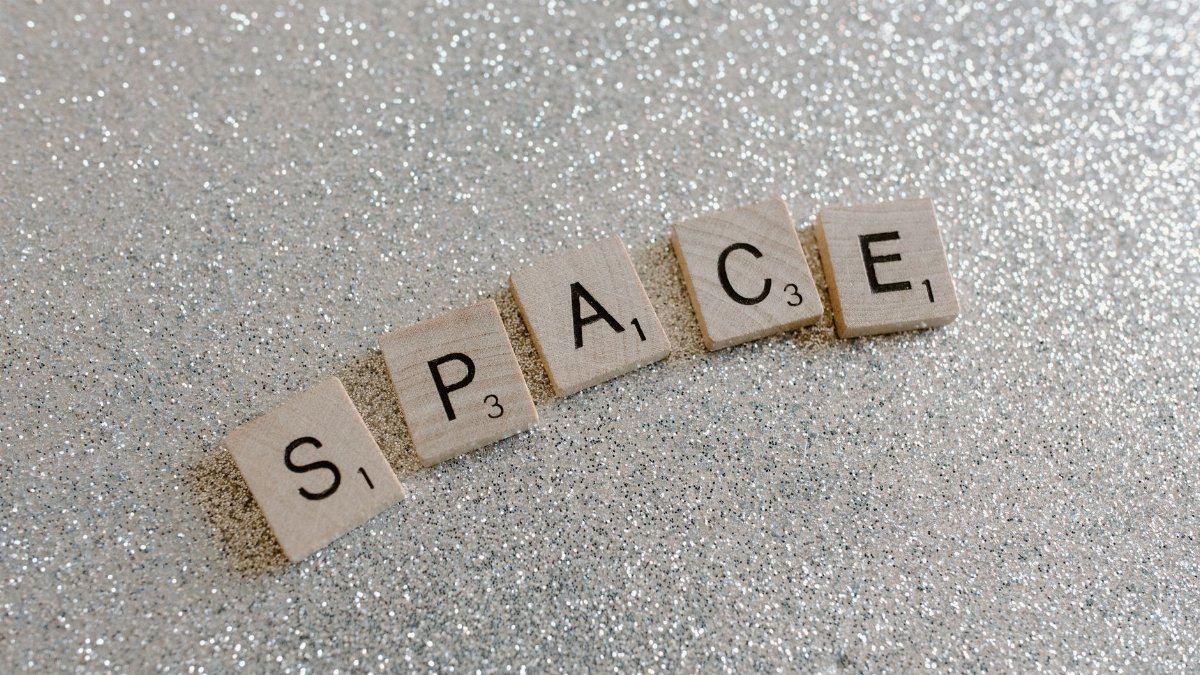 Wooden Scrabble tiles spelling 'Space' on a glittering background, perfect for concepts and ideas.