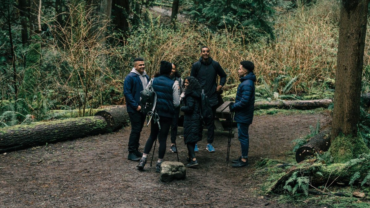 A group of friends enjoy a hiking trip in a lush forest, perfect for outdoor leisure.