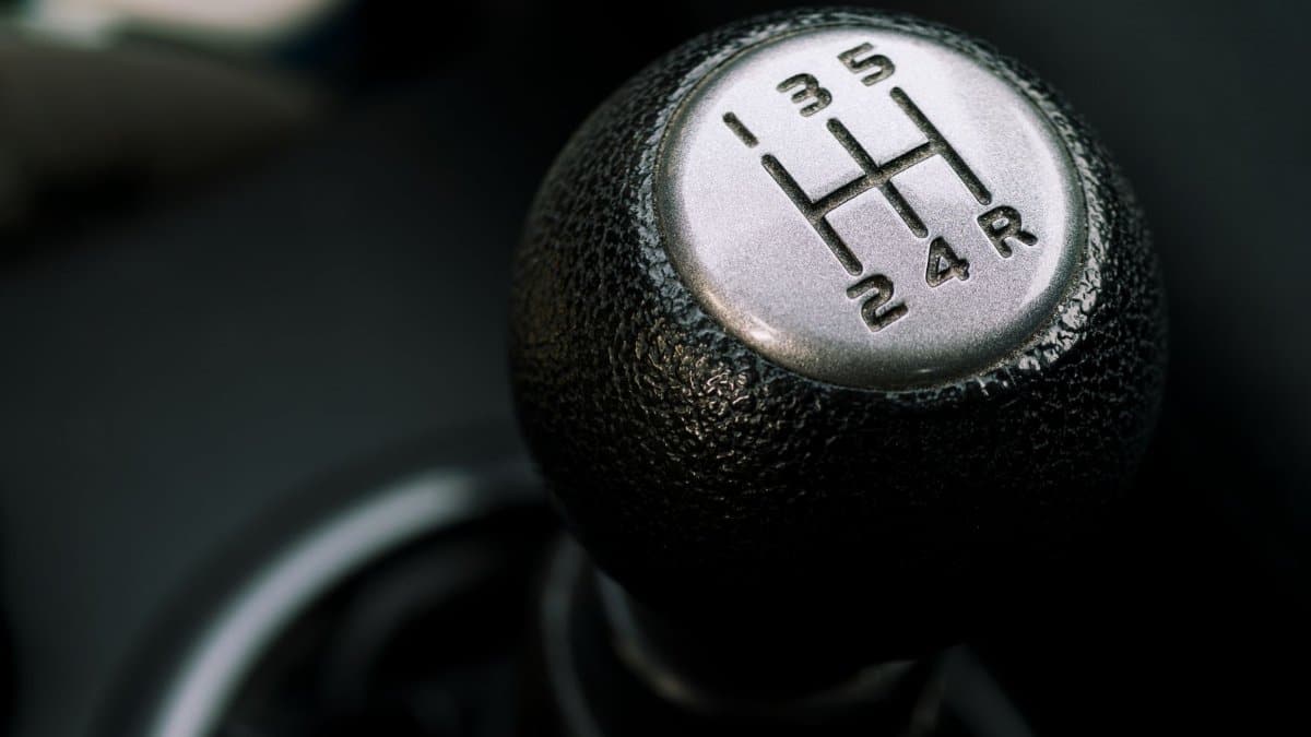 Detailed image of a manual transmission gear shift lever with visible gear pattern.