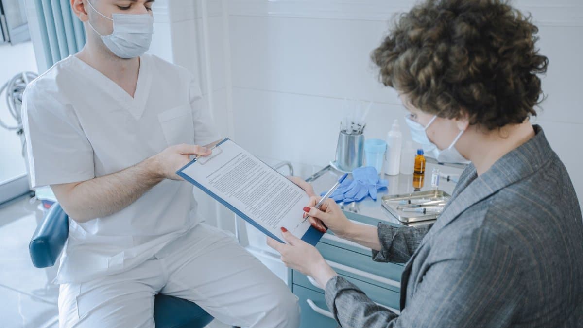 A medical professional and patient reviewing documents in a clinic setting.