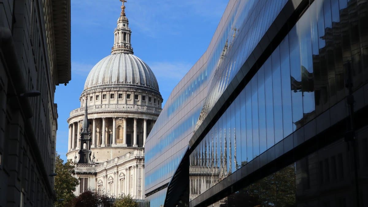 St. Paul's Cathedral dome seen alongside modern glass architecture in London.