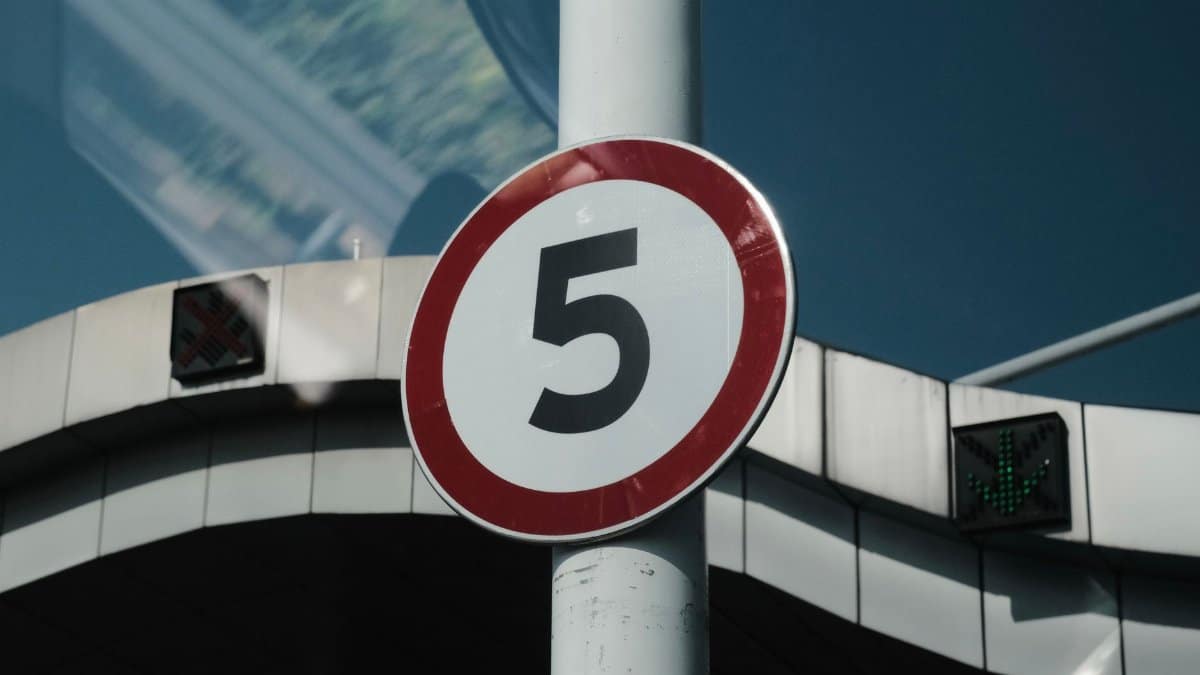 Close-up of a speed limit sign on a street pole in an urban setting.