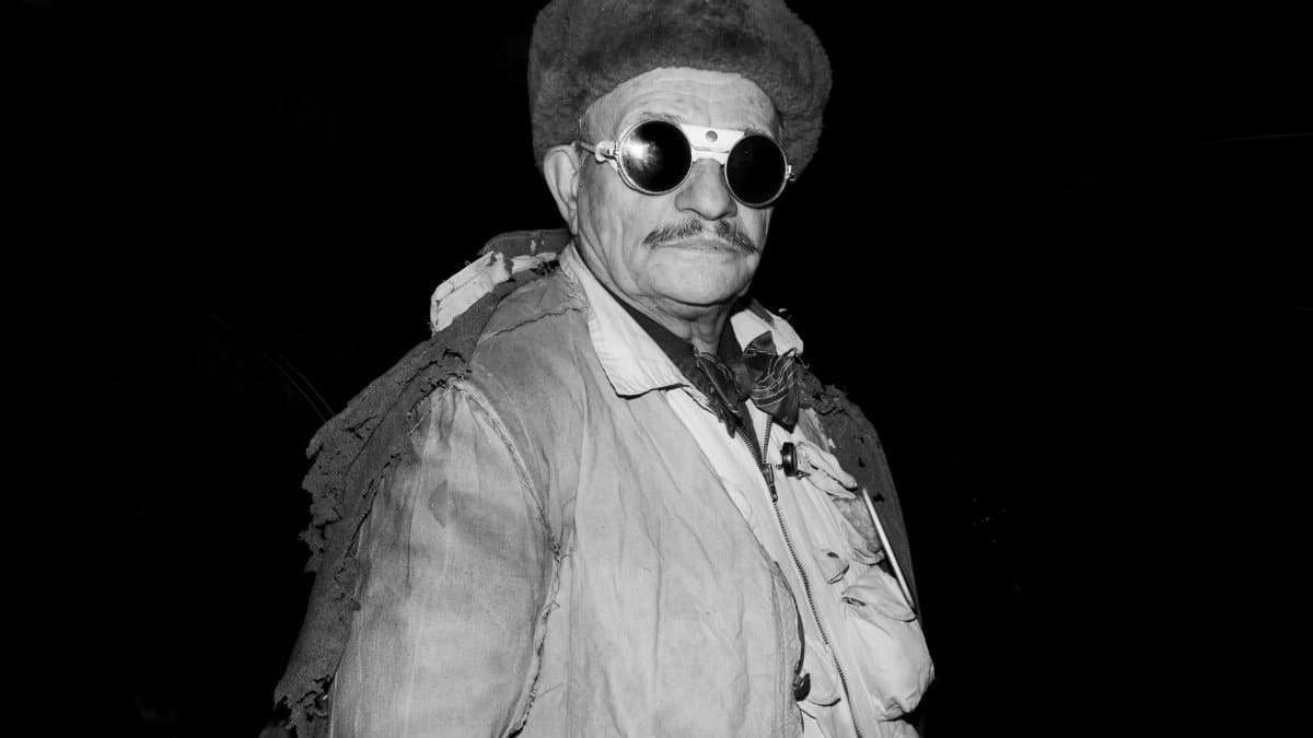 Striking black and white portrait of a man wearing retro goggles and a fur hat.