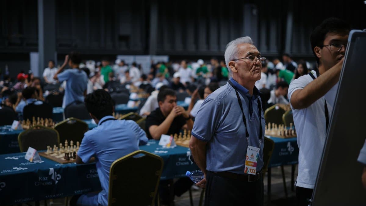 A bustling indoor chess tournament with players deeply focused on their games.