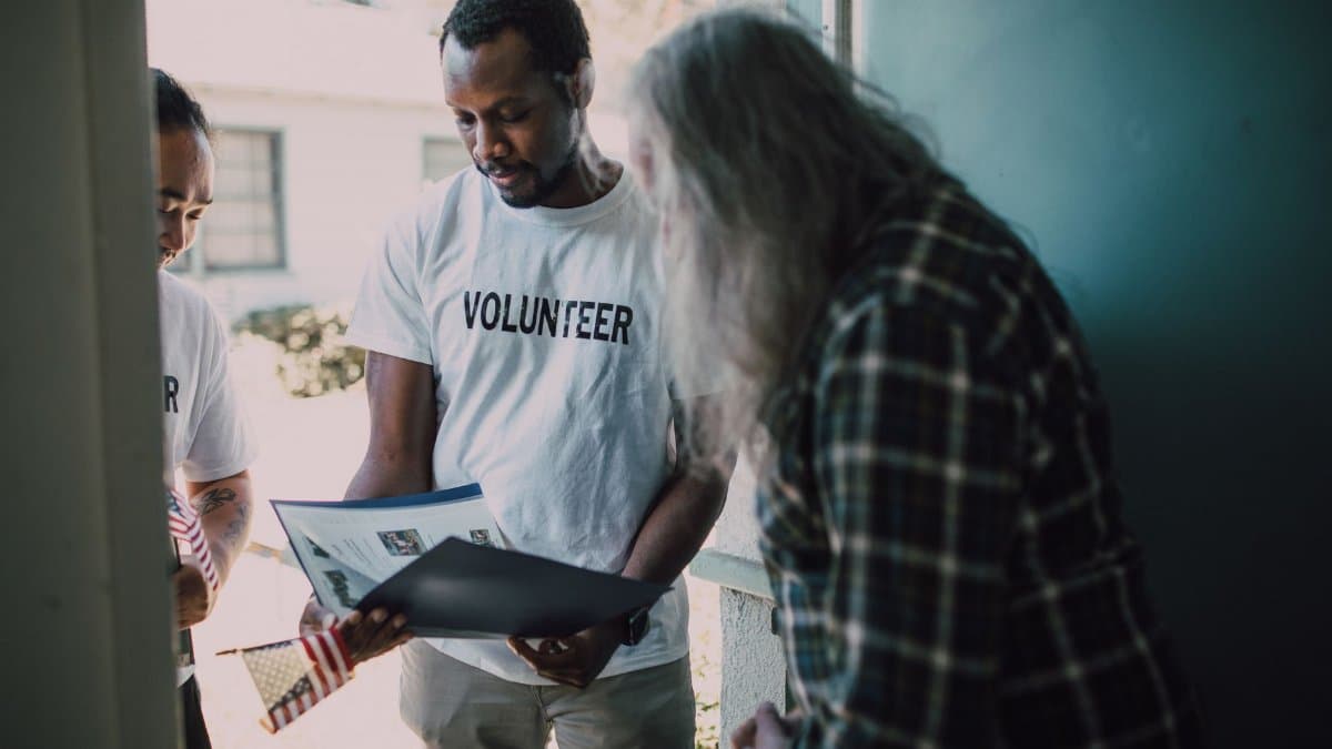 Volunteers visit a home to provide community support and discuss documents.