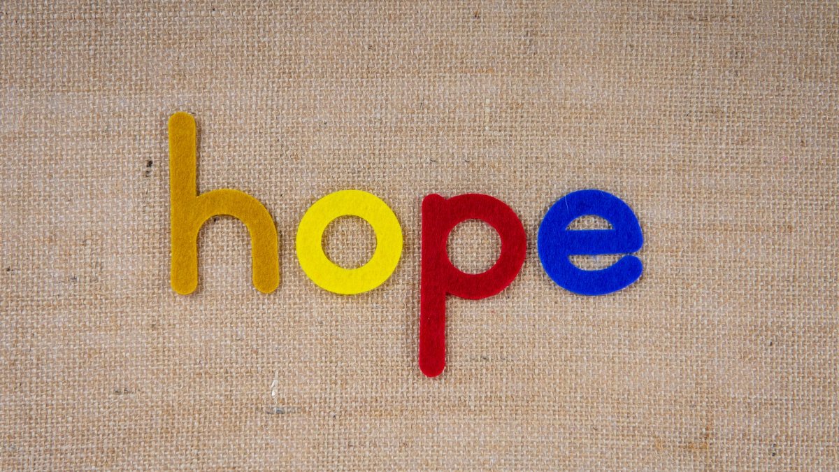 Close-up of colorful letters spelling 'hope' on a textured fabric background.