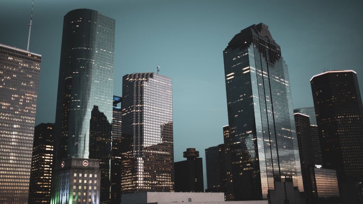 Nighttime view of Houston's modern skyline featuring illuminated skyscrapers against a dark sky.