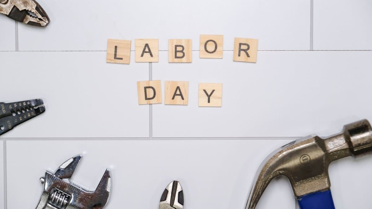 Labor Day themed image with tools and Scrabble tiles spelling 'Labor Day'.