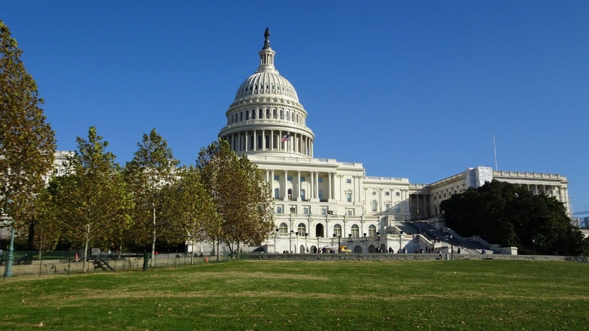 A stunning daytime view of the United States Capitol in Washington DC with a clear blue sky.