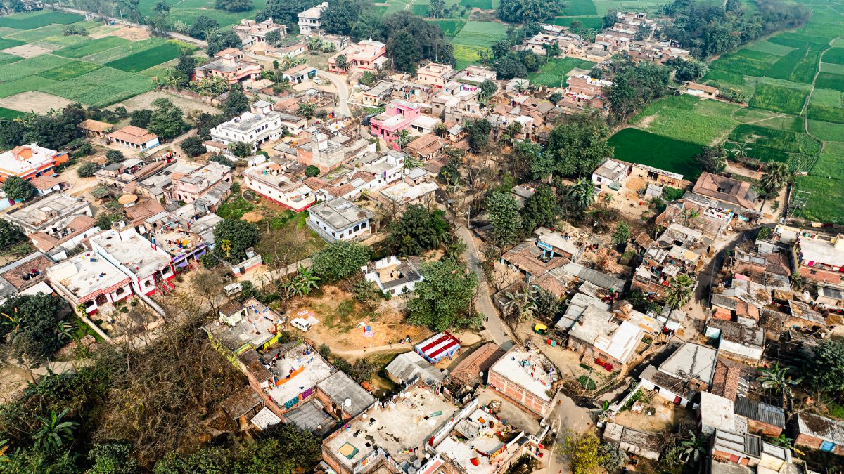 Aerial photo of a rural village surrounded by lush green fields.