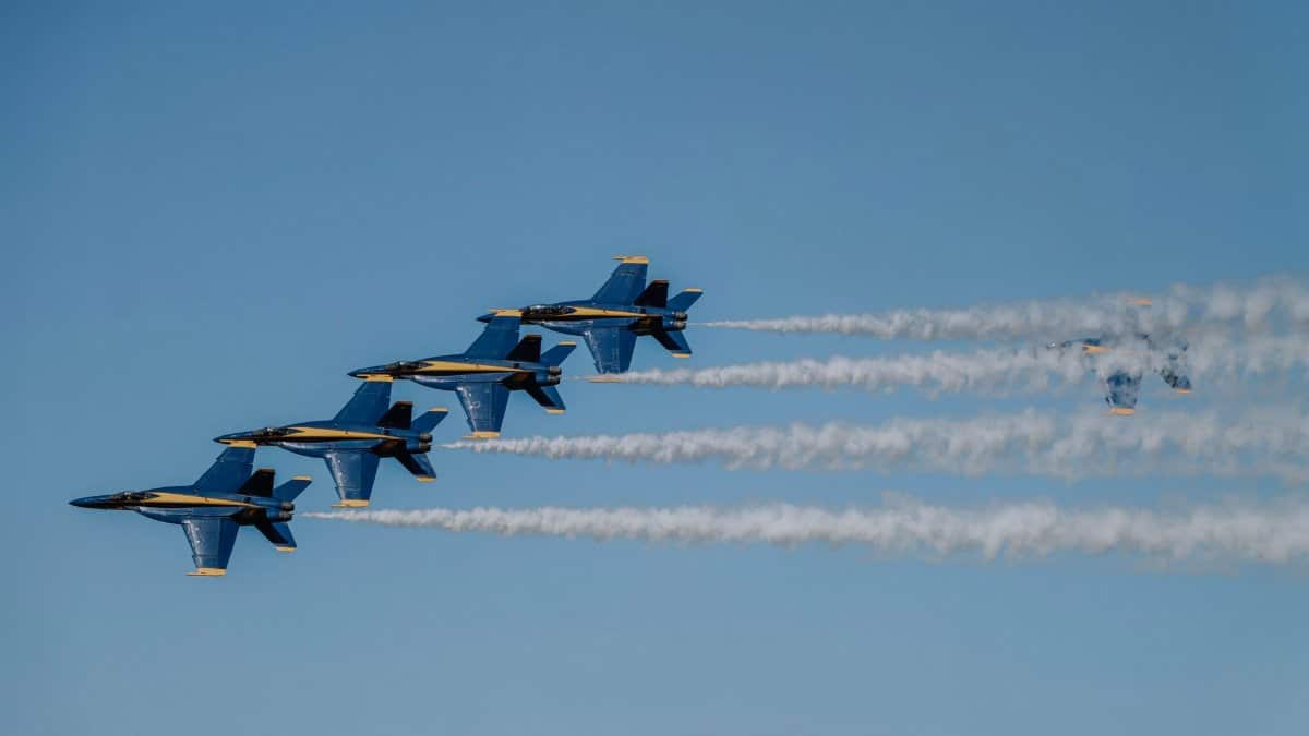 Blue Angels jets performing an impressive aerial formation against a clear blue sky.