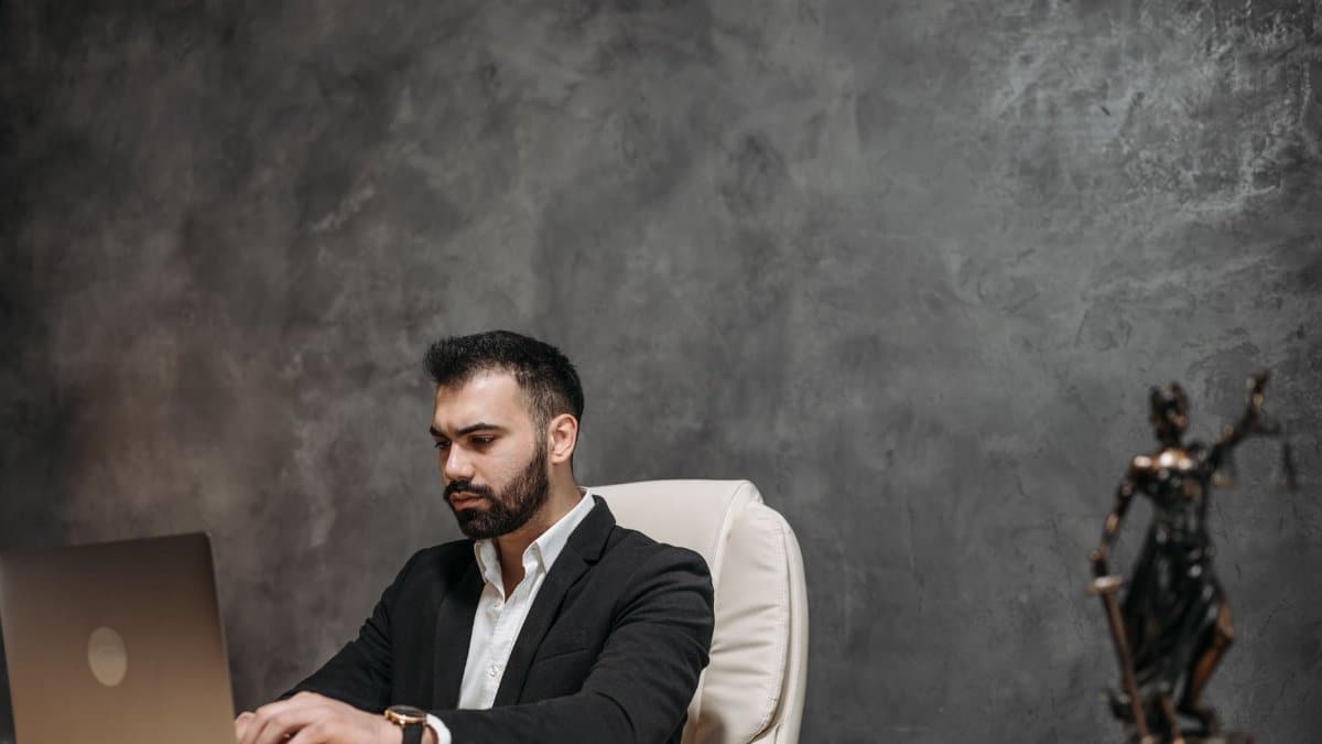 Focused professional man in an office environment working on a laptop.