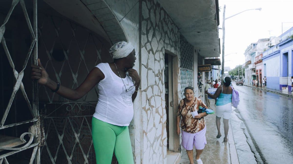 People interacting in a city street during a rainy day, showcasing urban life.