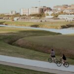 Bicyclists ride along a scenic path in Fort Worth, capturing the essence of outdoor activity.