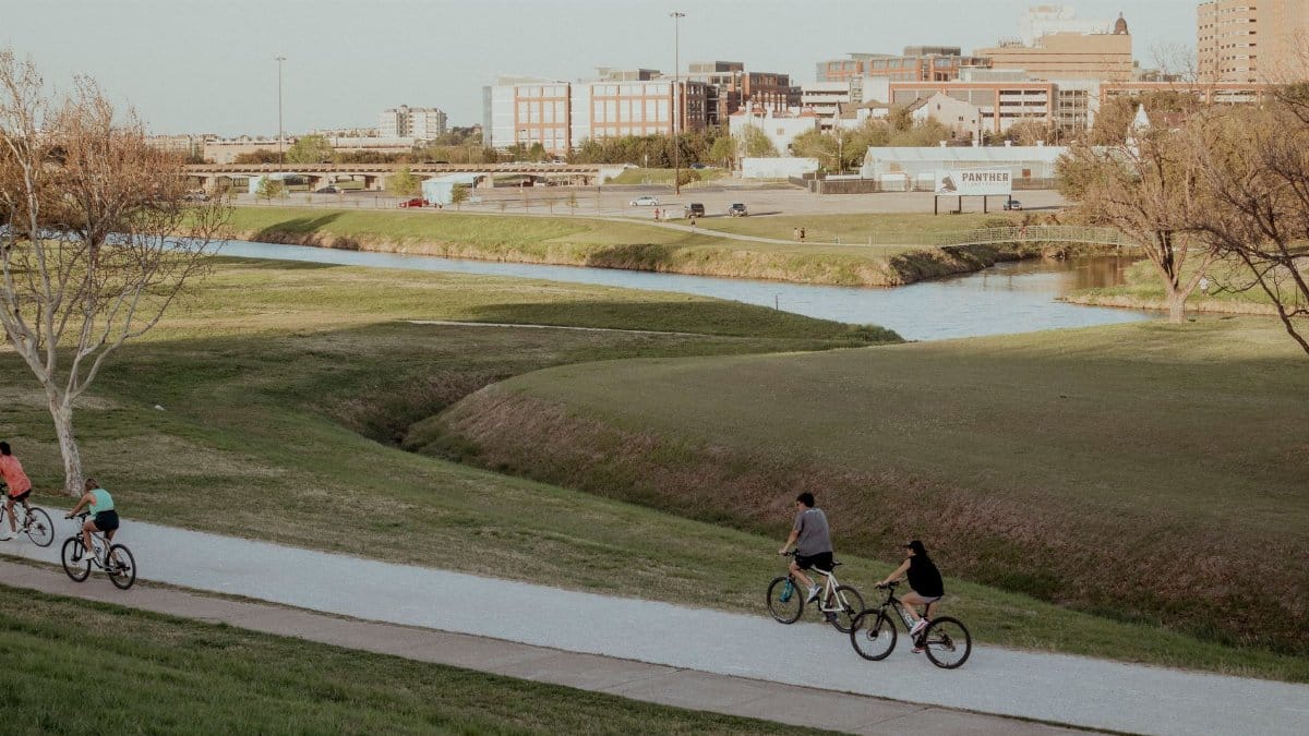 Bicyclists ride along a scenic path in Fort Worth, capturing the essence of outdoor activity.
