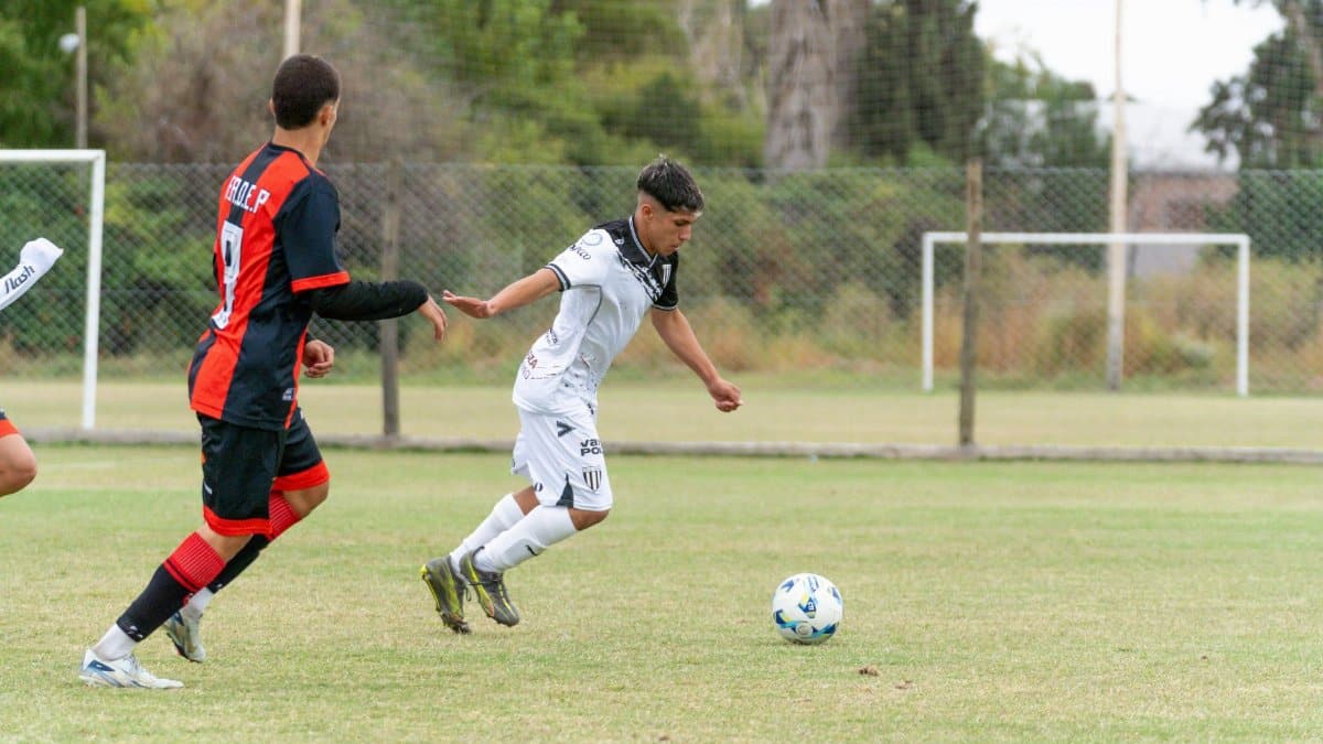 Dynamic action in a youth soccer match between players on a grass field.