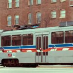 A light rail transit passing through an urban cityscape with brick buildings.