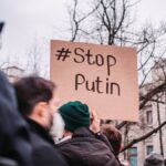 People in Berlin protest against Putin with anti-war signs, showing unity for peace.