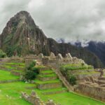 Iconic view of Machu Picchu surrounded by misty Andes peaks in Peru, highlighting its ancient Inca heritage.