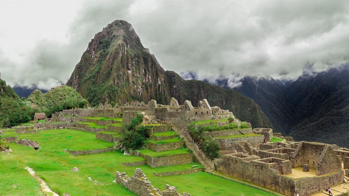 Iconic view of Machu Picchu surrounded by misty Andes peaks in Peru, highlighting its ancient Inca heritage.