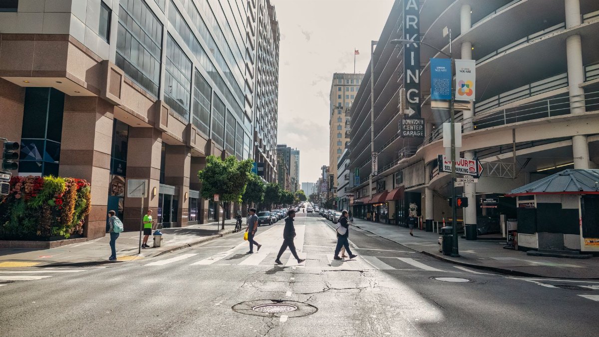 Street scene in San Francisco showcasing urban architecture and diverse pedestrians crossing.