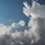 A captivating sky filled with cumulus clouds against a bright blue backdrop, showcasing dynamic weather patterns.