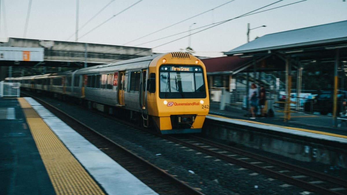 Queensland Rail train arrives at Loganlea Station in Queensland, Australia, showcasing public transport.