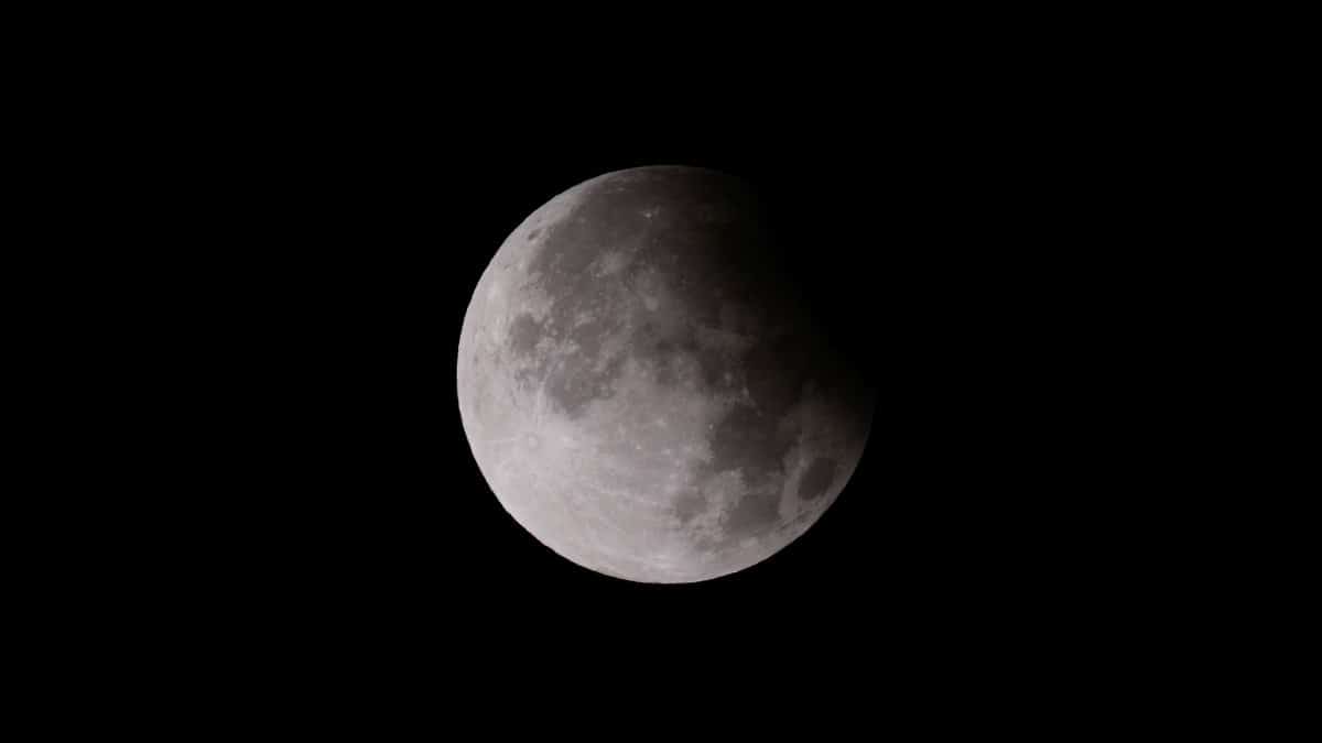 Close-up shot of a lunar eclipse, showcasing the moon's surface with shadow play.
