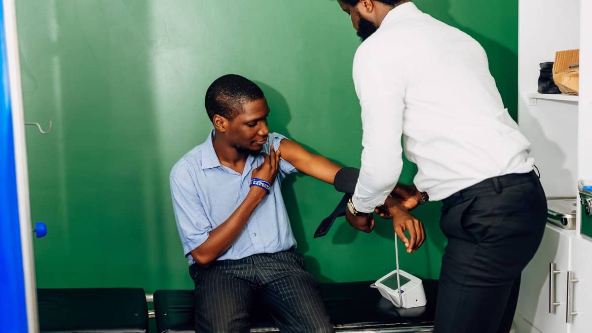 A healthcare professional checks a patient's blood pressure in a clinic in Lagos, Nigeria.