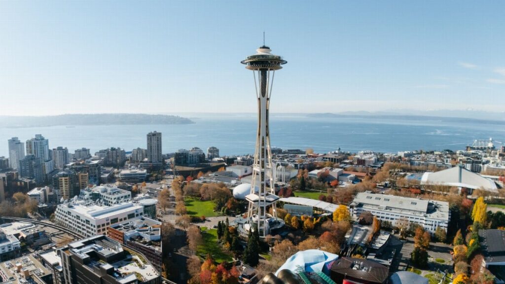 Aerial view of Seattle featuring the iconic Space Needle against a clear blue sky.