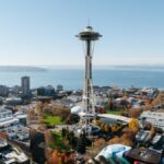 Aerial view of Seattle featuring the iconic Space Needle against a clear blue sky.