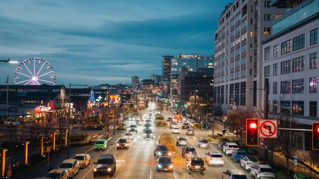 Busy evening in Seattle with city lights and iconic Ferris wheel along the waterfront.