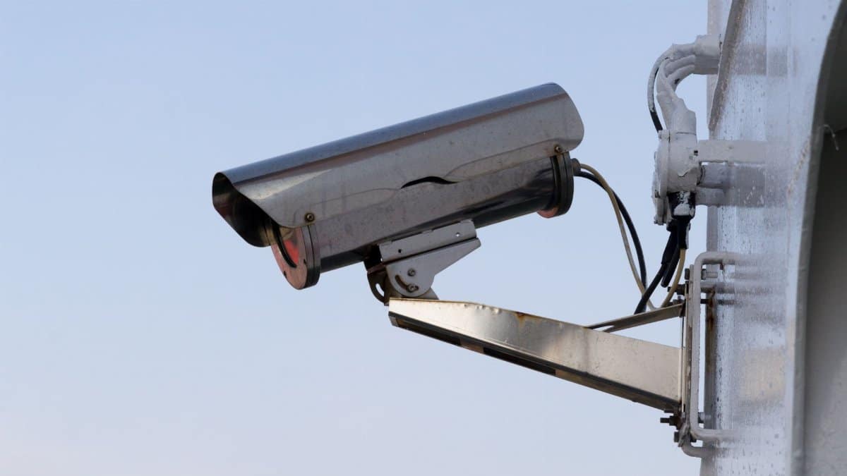 Close-up of an outdoor CCTV camera installed on a wall for security purposes.