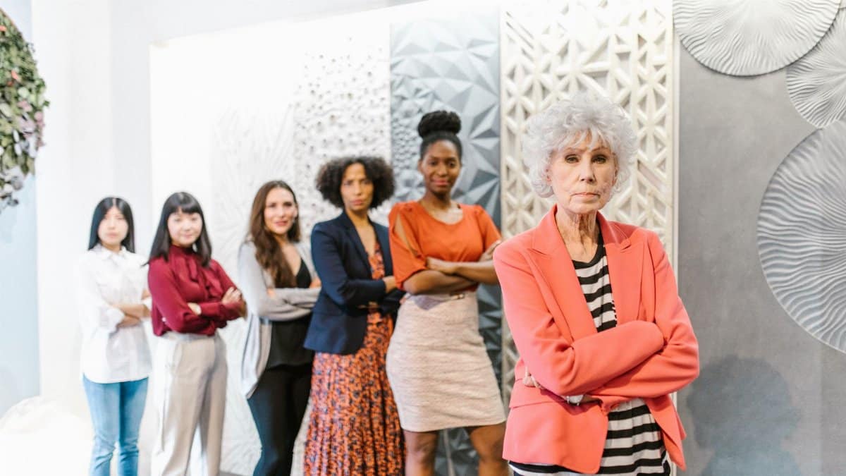A diverse group of business women standing together in a modern office setting displaying leadership and confidence.