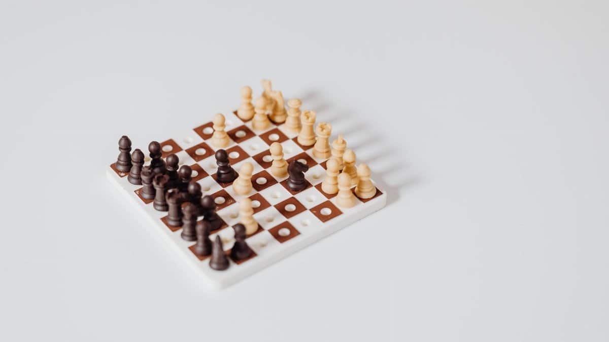 A minimalist miniature chess set arrangement on a white background, ideal for strategy concepts.