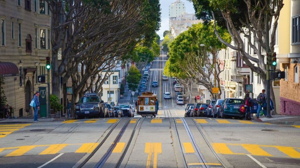 A vibrant city street in San Francisco featuring a classic cable car and iconic architecture.