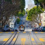 A vibrant city street in San Francisco featuring a classic cable car and iconic architecture.