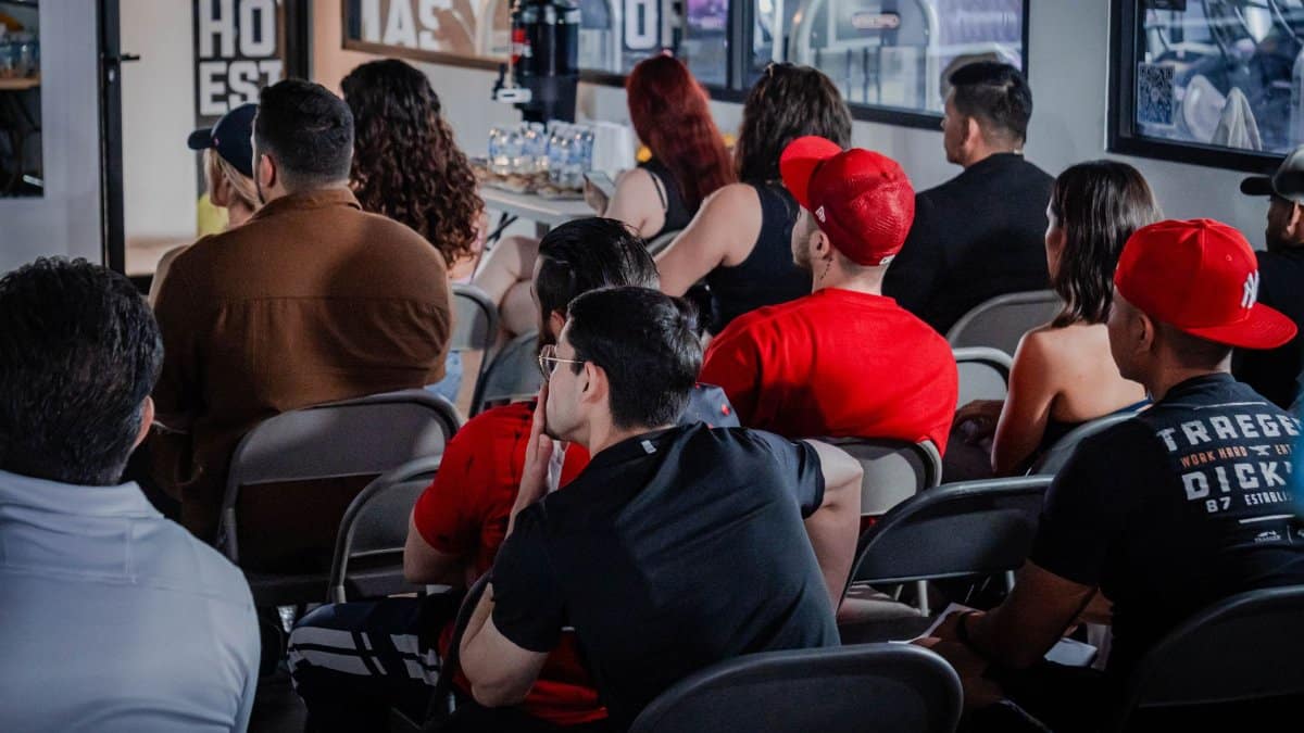 A diverse audience attentively participates in an indoor seminar setting, highlighting education and engagement.