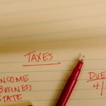 Close-up of tax-related notes on a yellow legal pad with red pen, highlighting important due dates.
