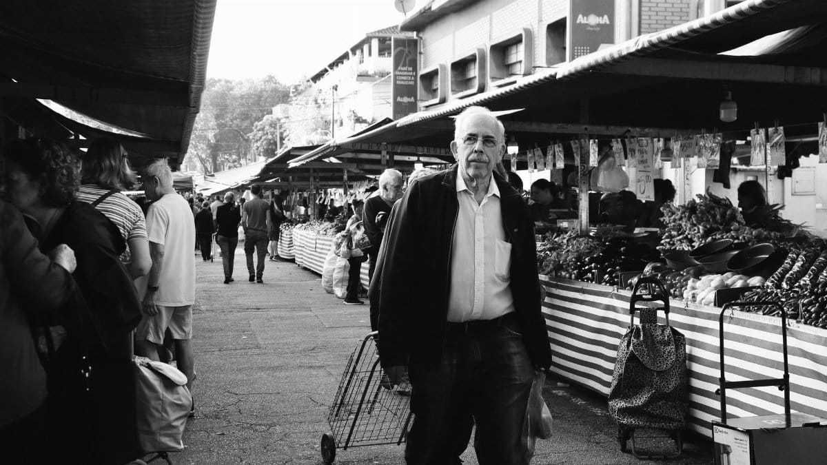 Street market bustling with shoppers captured in a timeless black and white photograph.
