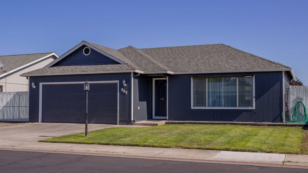 Charming suburban house with driveway, garage, and well-maintained lawn.