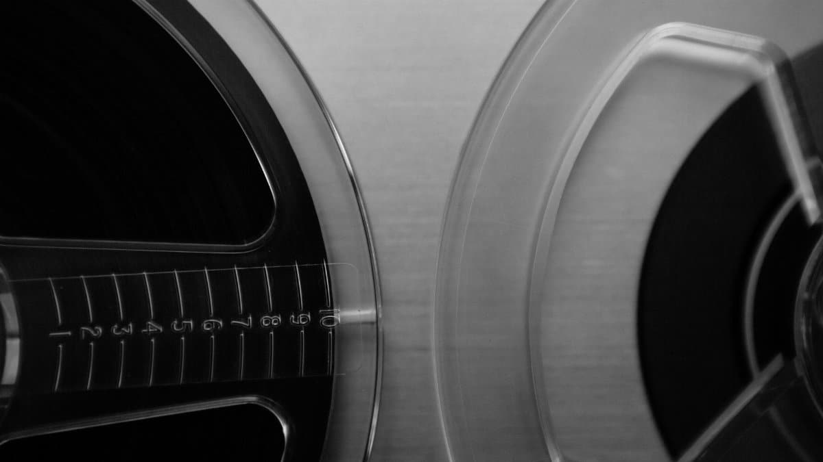 Close-up of vintage audio reel-to-reel tape in black and white.