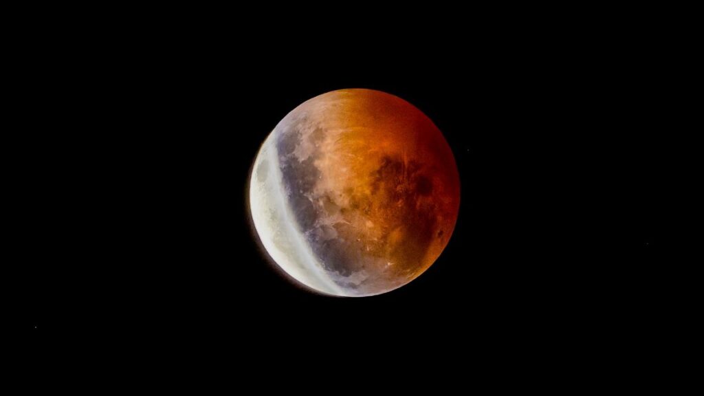A mesmerizing blood moon during a lunar eclipse against a dark night sky.