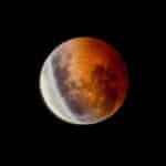 A mesmerizing blood moon during a lunar eclipse against a dark night sky.