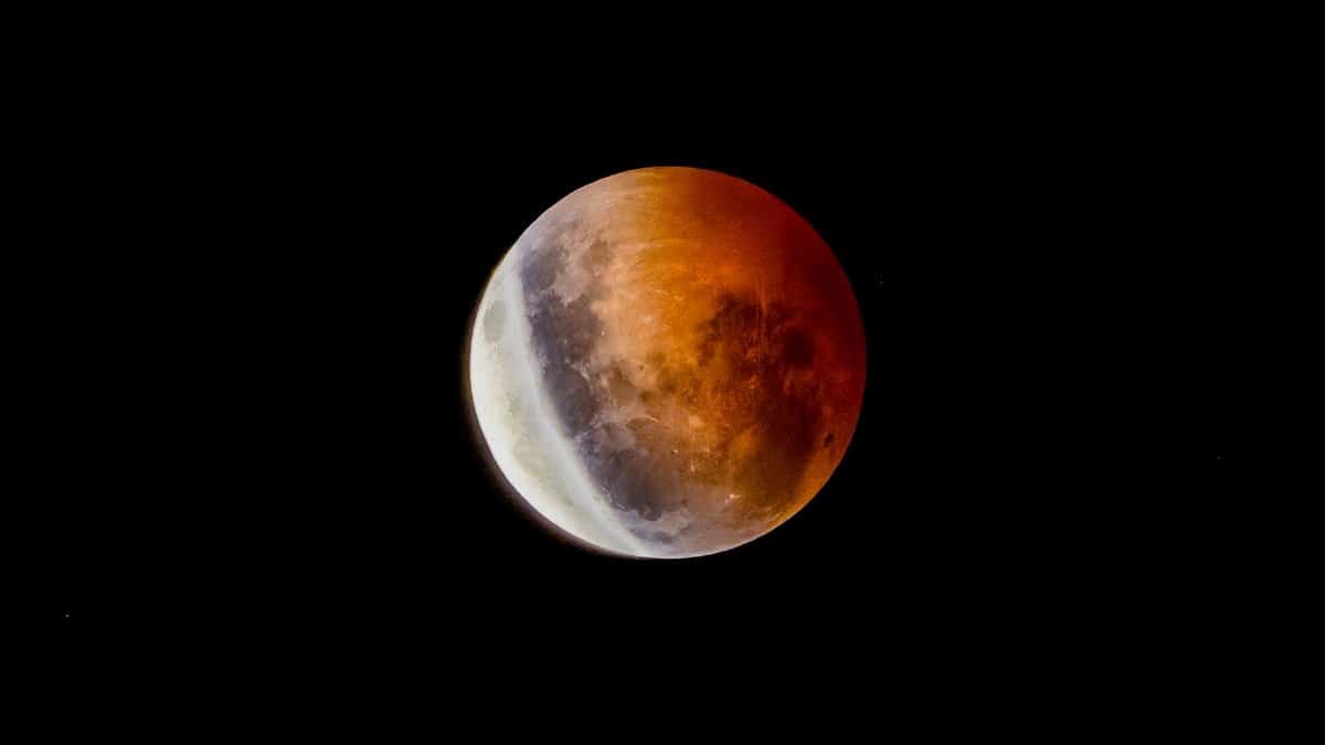 A mesmerizing blood moon during a lunar eclipse against a dark night sky.