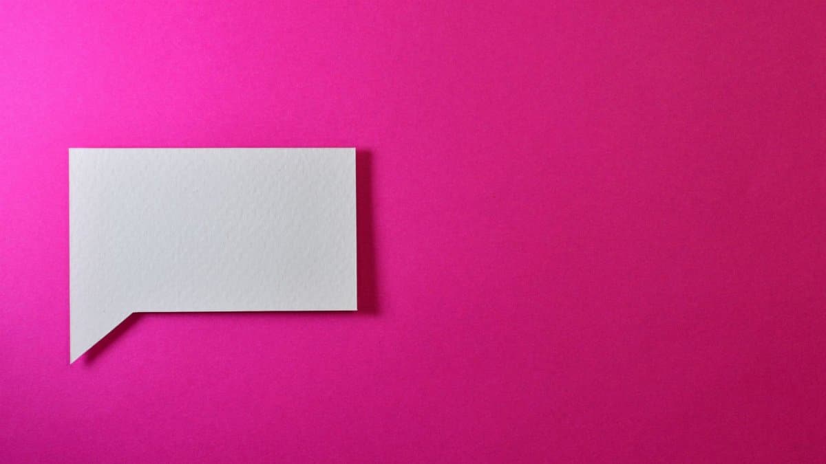 A minimalistic white paper speech bubble on a vibrant pink background, perfect for design projects.